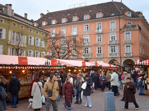 KI-generierte repräsentative Illustration. Fotovorlage: Rot-weiße Marktdächer auf dem Bozner Waltherplatz. Aufgenommen 2006; dieses Archivfoto zeigt nicht die Gestaltung von 2026.