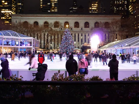 KI-generierte repräsentative Illustration. Fotovorlage: Eislaufbahn und Weihnachtsbaum im Bryant Park in New York bei Nacht. Archivfoto von 2013; zu sehen ist eine frühere Gestaltung.