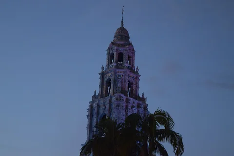 California Tower e palmeiras no Balboa Park, em San Diego, ao anoitecer. Fotografia de arquivo de 2020, como referência da área e de sua arquitetura.
