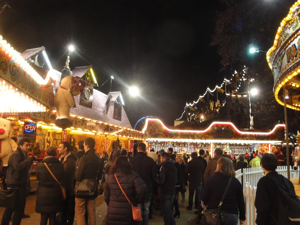 Visitantes entre barracas de jogos iluminadas no Hyde Park Winter Wonderland, em Londres. Fotografia de arquivo de 2011; mostra uma decoração de uma edição anterior.