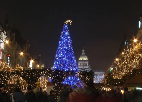 KI-generierte repräsentative Illustration. Fotovorlage: Blauer Weihnachtsbaum auf dem Wenzelsplatz mit dem Nationalmuseum dahinter. Aufgenommen 2005; dieses Archivfoto zeigt nicht die Gestaltung von 2026.