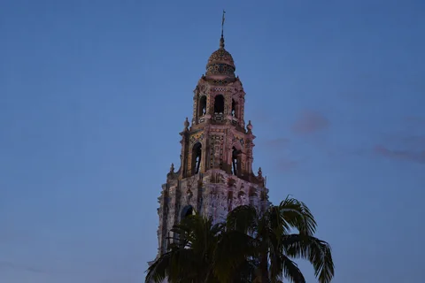 KI-generierte repräsentative Illustration. Fotovorlage: California Tower und Palmen im Balboa Park in San Diego in der Dämmerung. Archivfoto von 2020 zur Orientierung in der Umgebung und ihrer Architektur.
