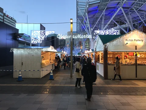 Weihnachtsmarktstände und Festbeleuchtung vor dem Bahnhof Hakata in Fukuoka. Archivfoto von 2018; zu sehen ist eine frühere Gestaltung.