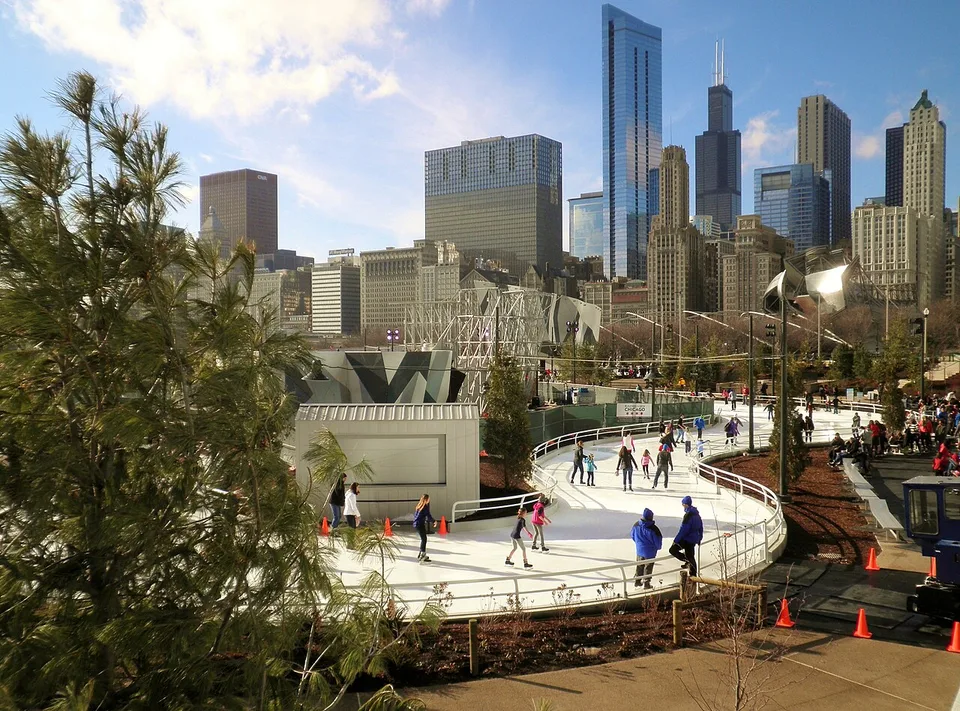 Eisläufer auf dem geschwungenen Skating Ribbon im Maggie Daley Park vor Chicagos Skyline, Dezember 2014. Historische Aufnahme.